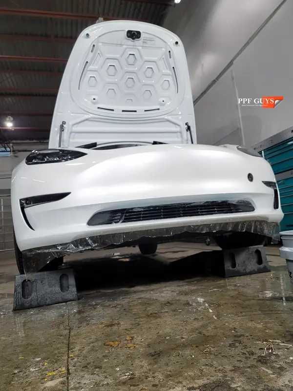 White Tesla Model 3, Front end, partial A-pillars, tinted headlights and fogs. Photo 11 of 18.