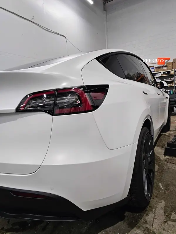 White Tesla Model Y Performance, Stealth, emblems. Photo 46 of 60.