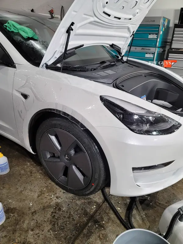 White Tesla Model 3, Front end, partial A-pillars, tinted headlights and fogs. Photo 13 of 18.