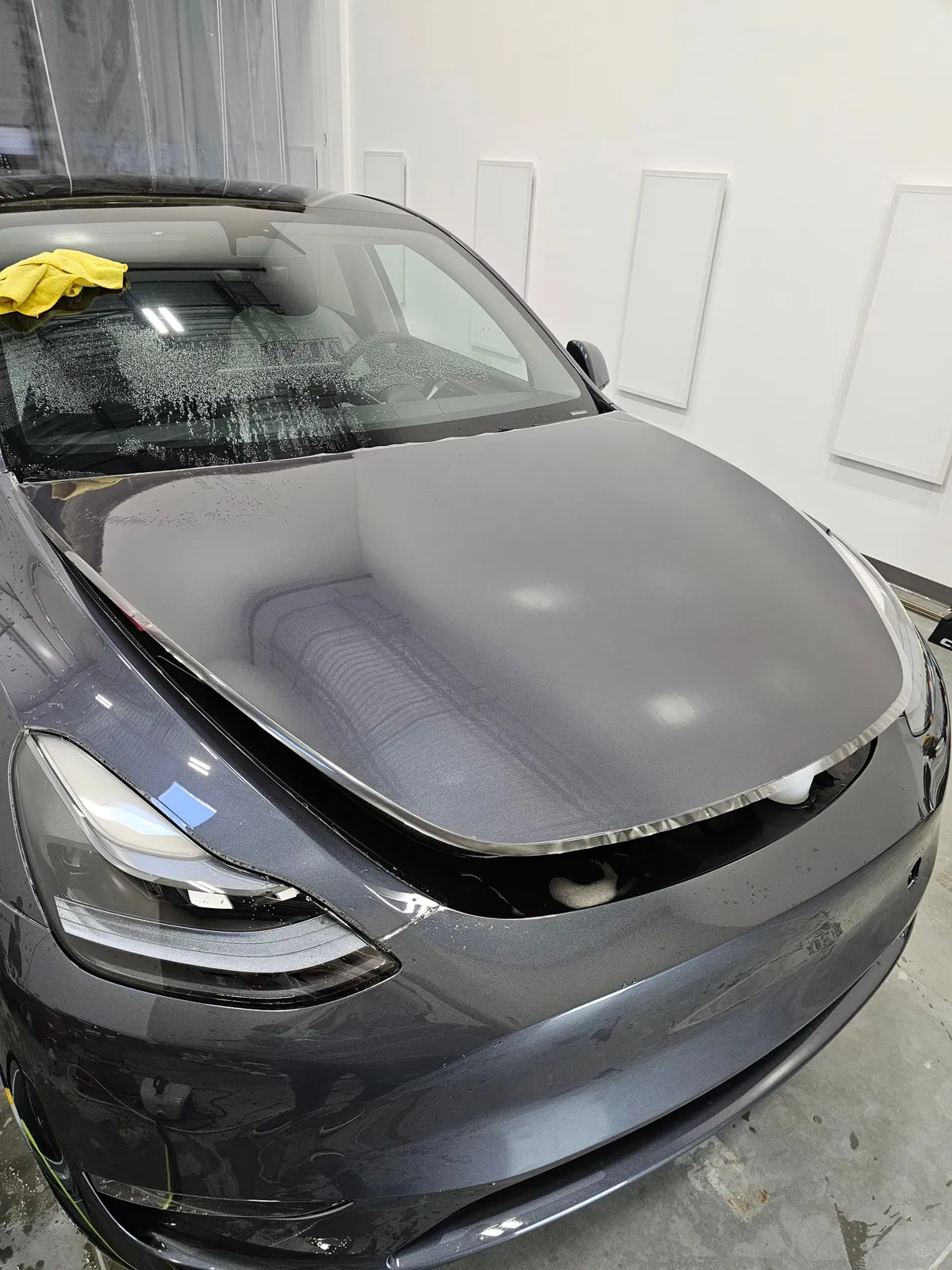 Grey Tesla Model Y hood with film applied, edges wrapped.