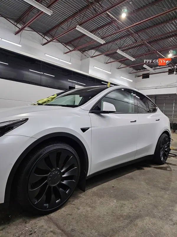 White Tesla Model Y Performance, Stealth, emblems. Photo 30 of 60.