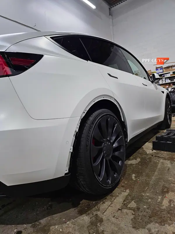 White Tesla Model Y Performance, Stealth, emblems. Photo 47 of 60.