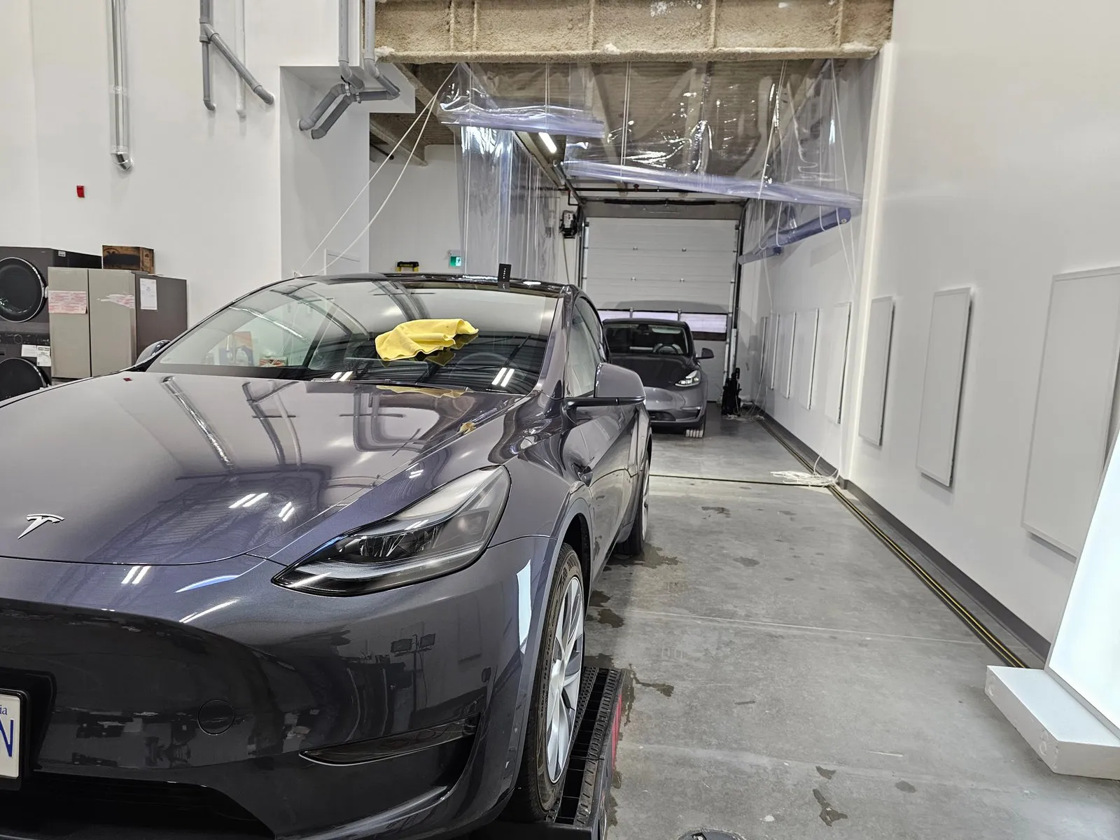 Two grey Tesla Model Y vehicles inside the PPF Guys install bay.