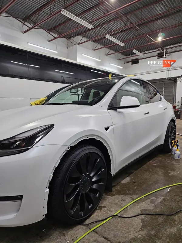 White Tesla Model Y Performance, Stealth, emblems. Photo 16 of 60.