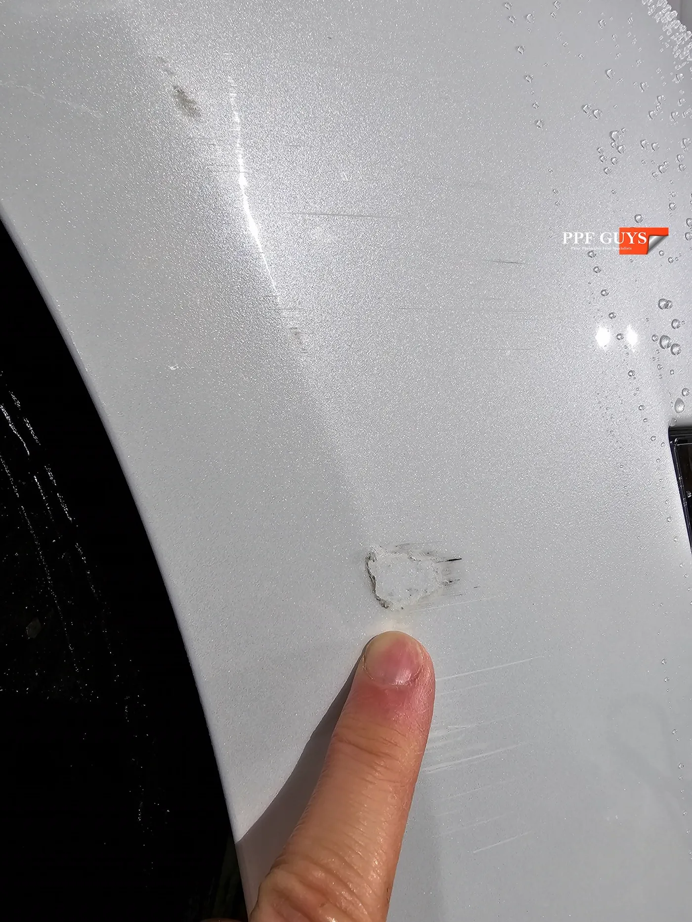 Scrape marks on the PPF covering the Model 3 bumper corner.